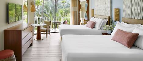 A hotel room with two beds, a desk, and a balcony with a view of palm trees.