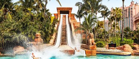 A water slide at a resort with a pool at the bottom.