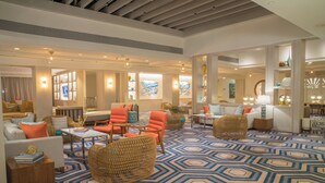 A spacious lobby with a geometric patterned carpet, comfortable seating areas, and modern decor.