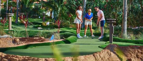 A golf course with a putting green, sand bunkers, and a water hazard.