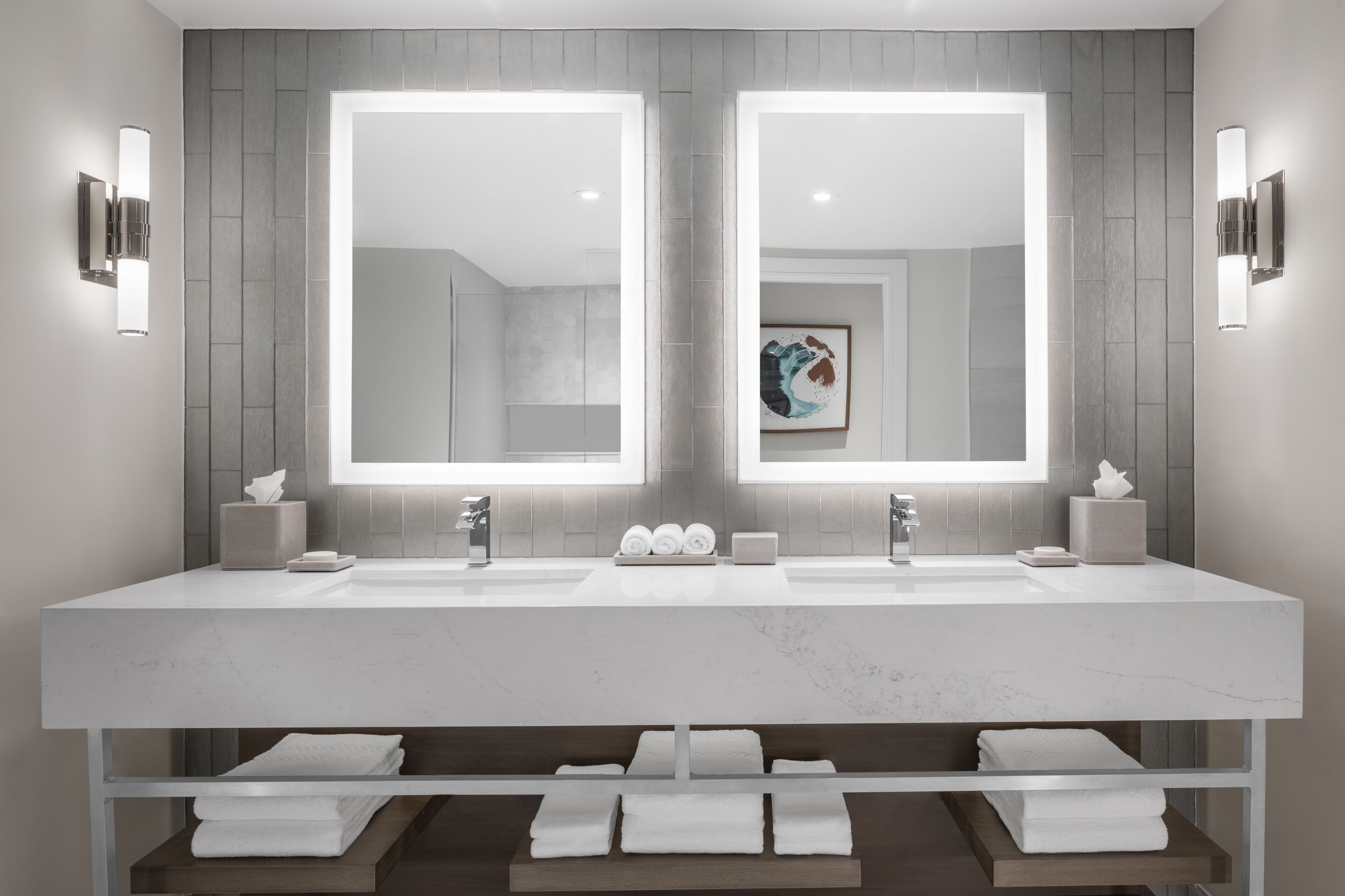 A modern bathroom with two sinks, large mirrors, and built-in towel racks.
