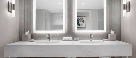A modern bathroom with two sinks, large mirrors, and built-in towel racks.