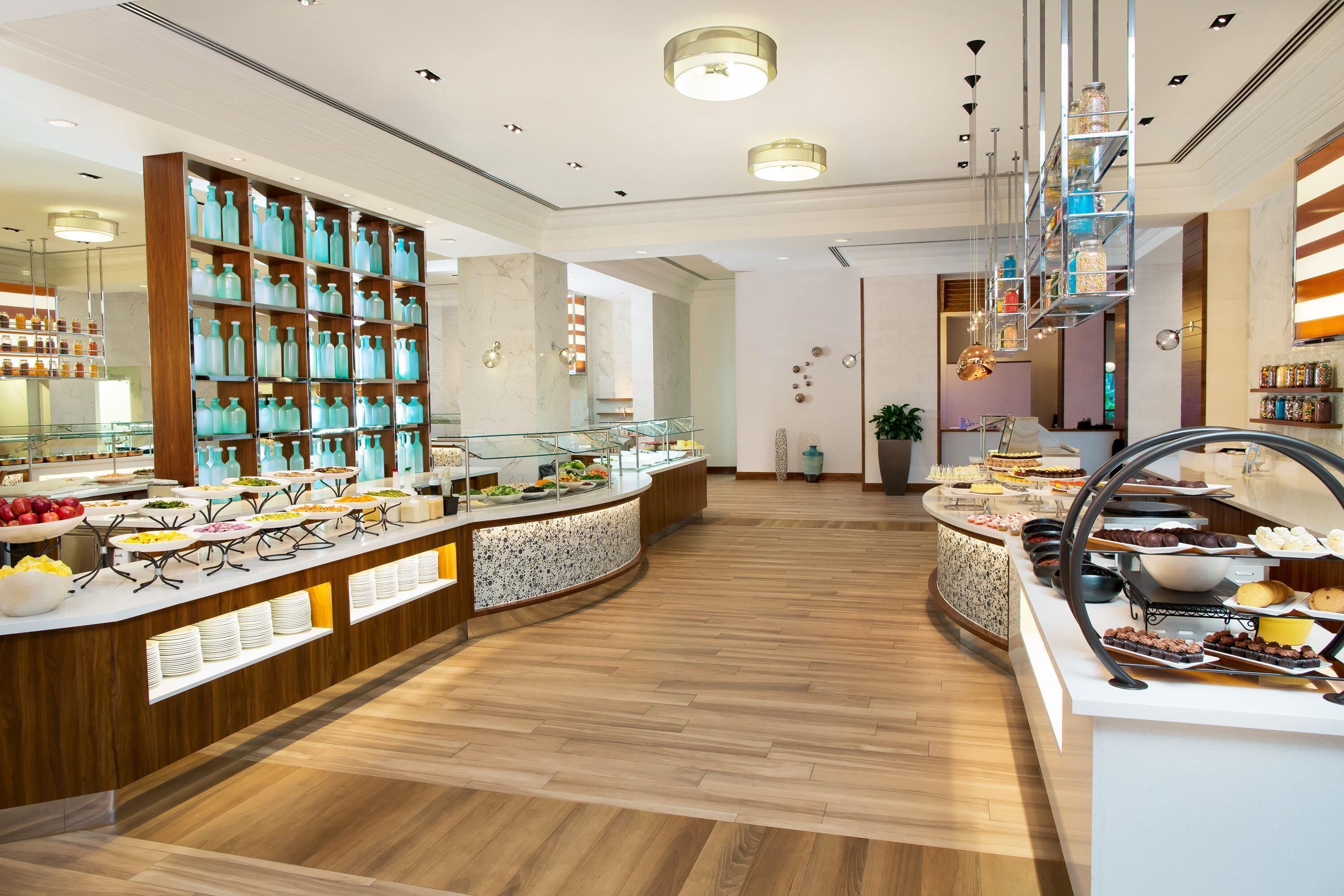 A buffet area with various food items and a large display of glass bottles.