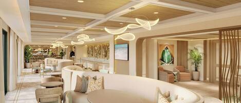 A modern hotel lobby with a curved seating area, a wooden ceiling, and a large screen.