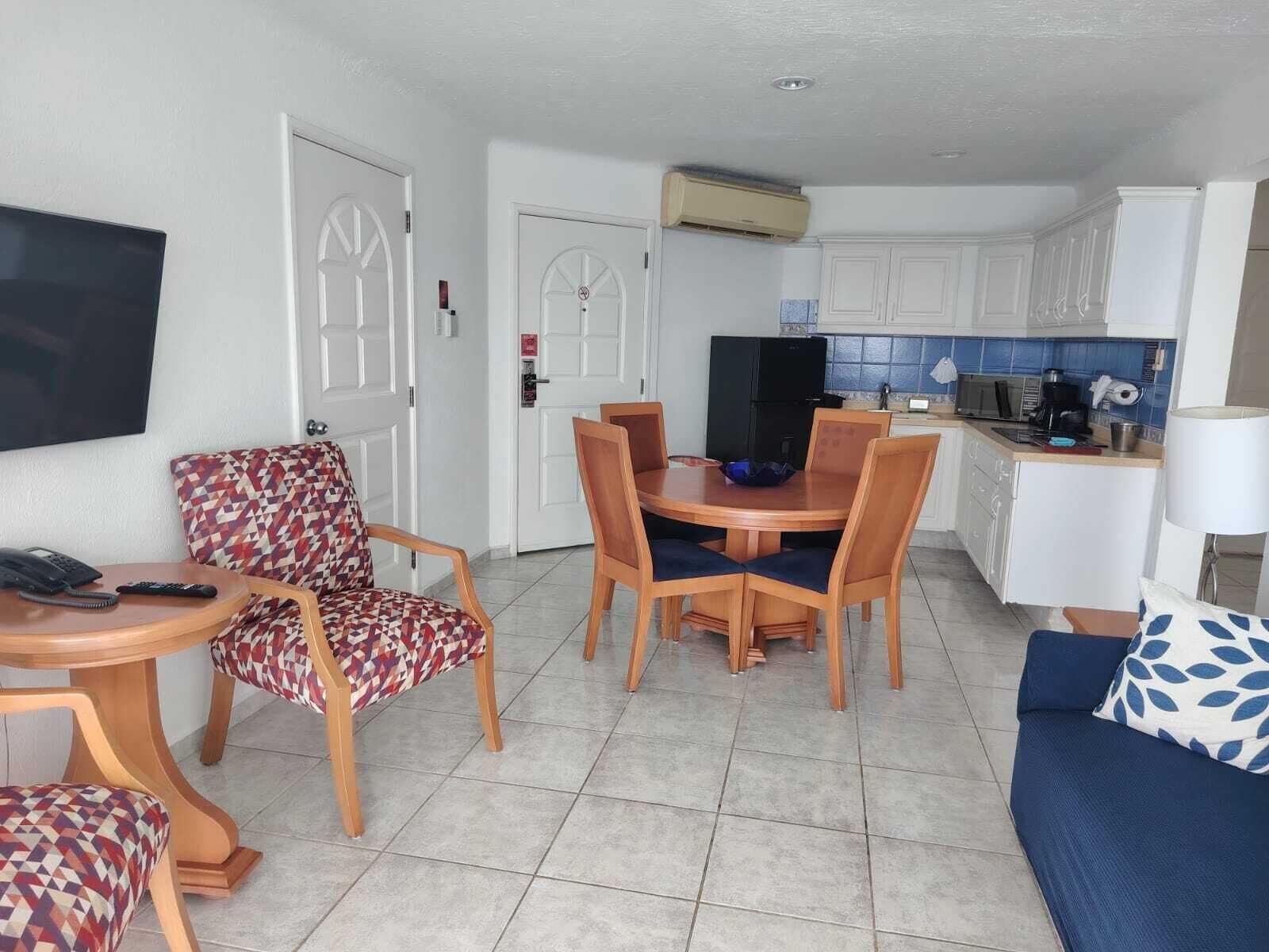 Un espacio habitable funcional con comedor, kitchenette y asientos.