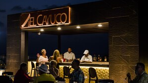 Un bar appelé « El Cayuco », avec une façade en pierre et une enseigne au-dessus de l’entrée.