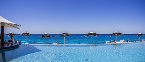 Piscine extérieure, parasols de plage, chaises longues