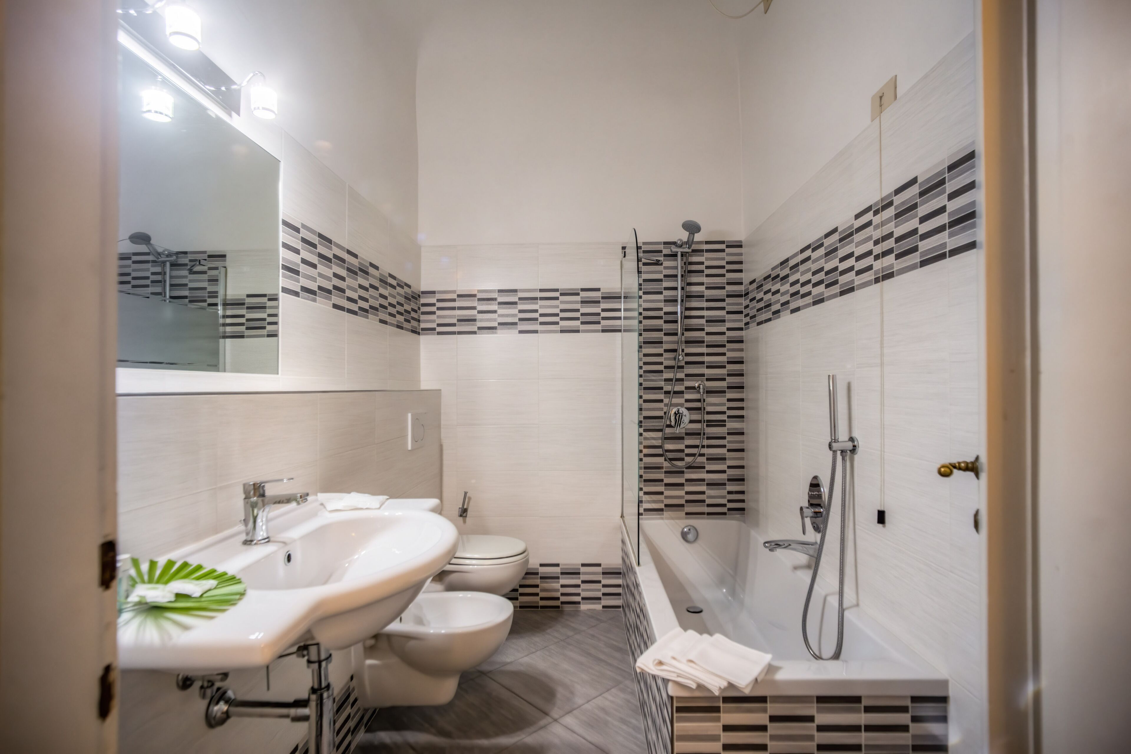 A modern bathroom with a sink, toilet, and shower area.