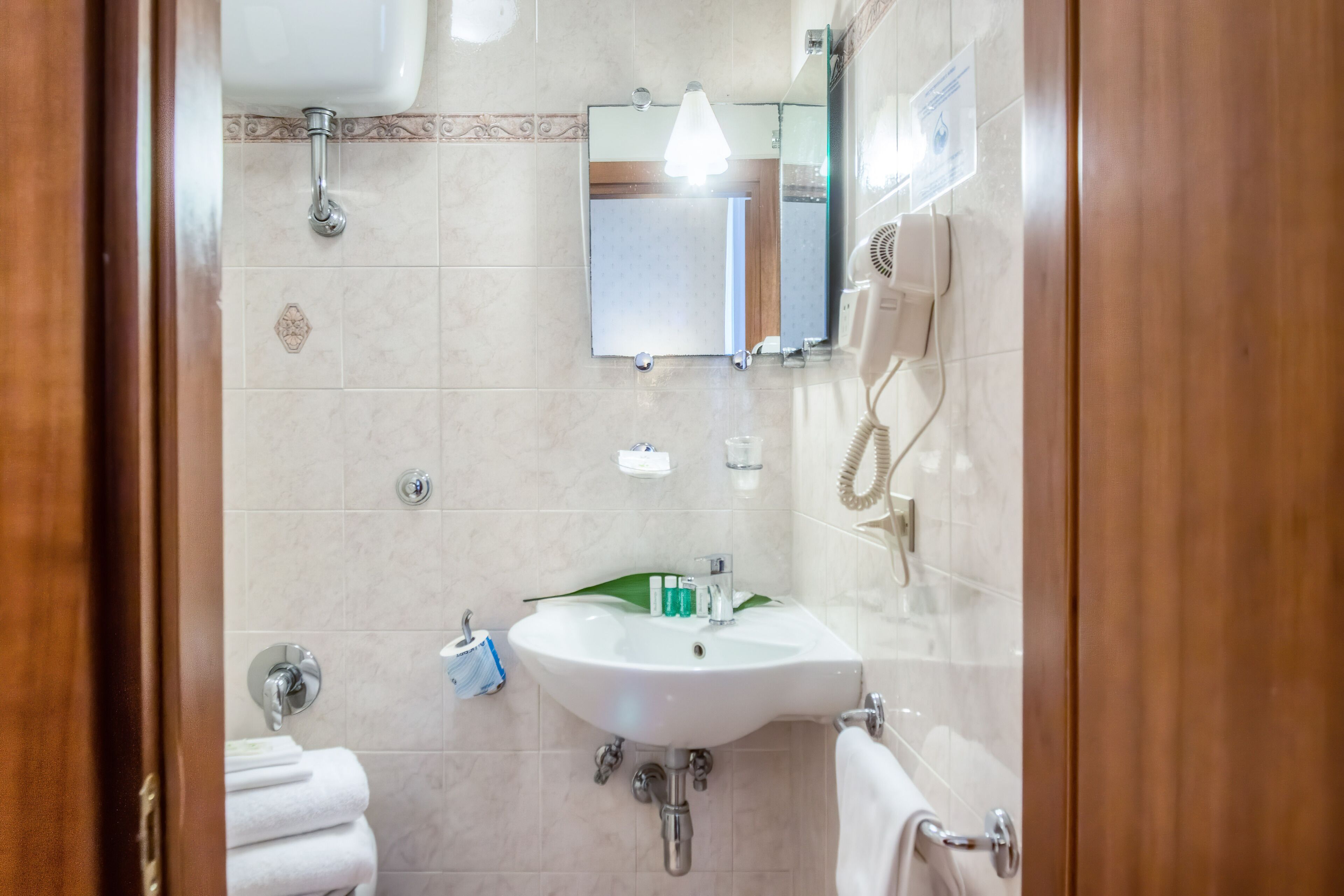 Une salle de bain équipée d’un lavabo, d’un miroir et d’un porte-serviettes.