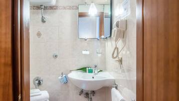 Une salle de bain équipée d’un lavabo, d’un miroir et d’un porte-serviettes.