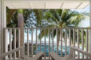 A balcony with a view of a pool and palm trees. - Grand Decameron Montego Beach, A Trademark All Inc (Montego Bay)