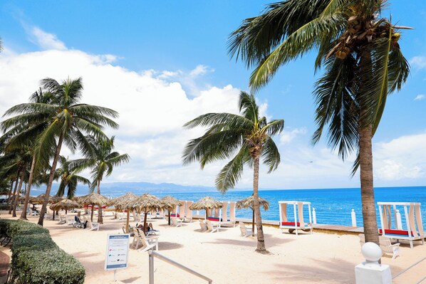 Plage privée, sable blanc, chaises longues, serviettes de plage