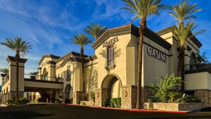 Un hotel con un grande cartello da casinò, finestre ad arco e una galleria coperta.
