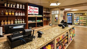 A hotel lobby with a self-service kiosk, shelves stocked with various liquor brands, and a refrigerated beverage display. - Silver Sevens Hotel and Casino, a Wyndham Garden (Las Vegas)