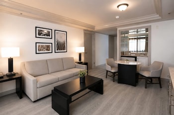 A hotel room with a bed, a desk, a chair, a TV, and a window with curtains. at Silver Sevens Hotel and Casino, a Wyndham Garden