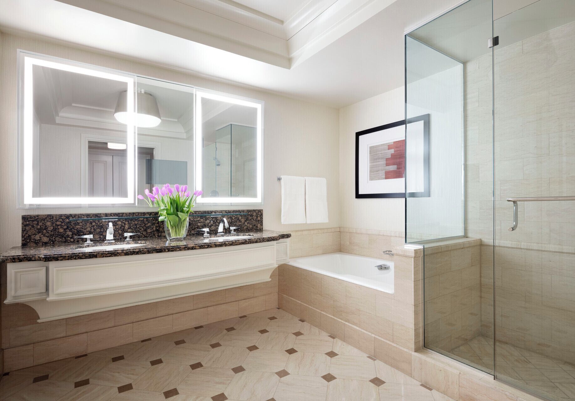 A modern bathroom with a large mirror, a bathtub, and a glass shower enclosure.