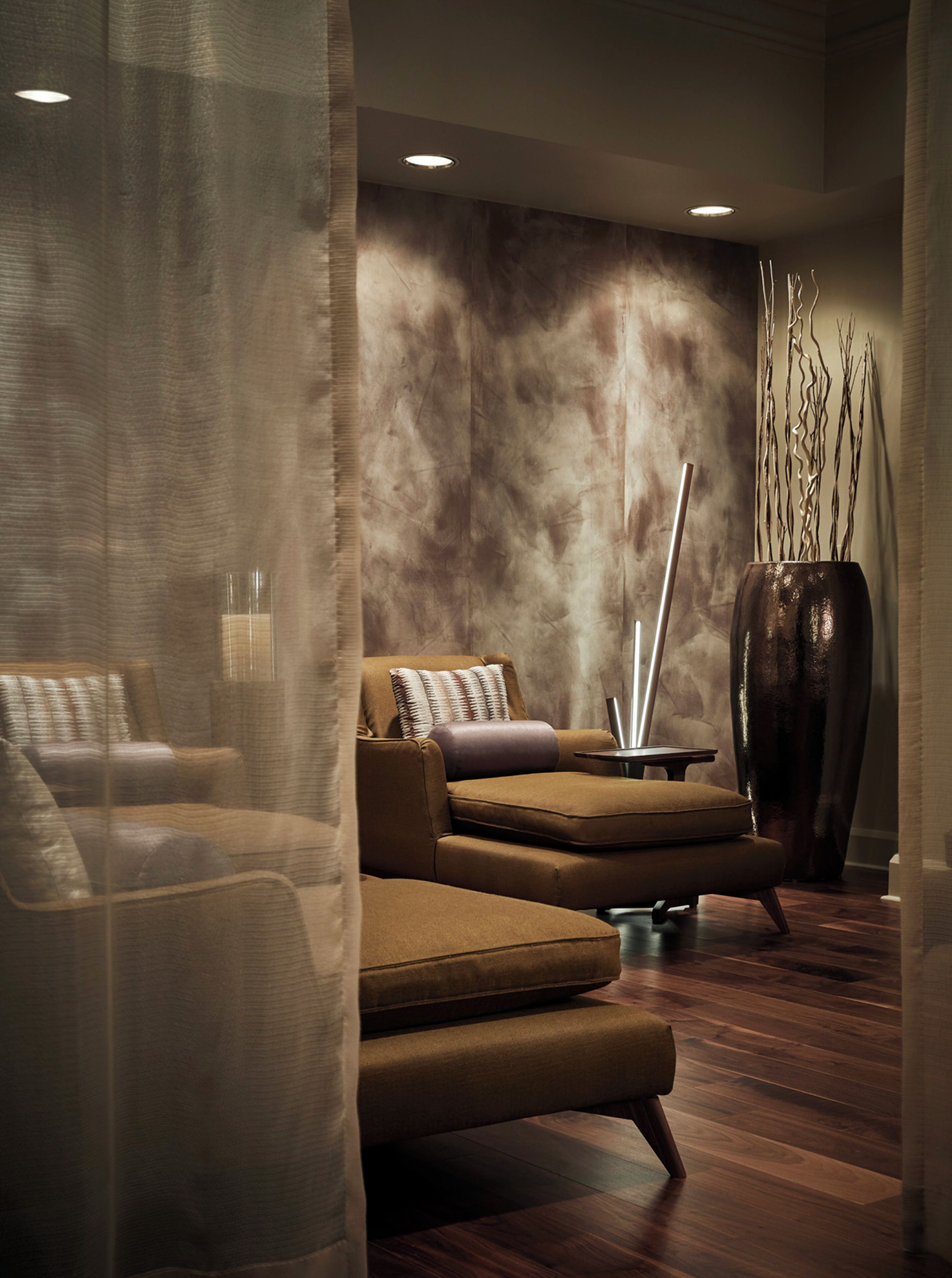 Ein stilvoller Lounge-Bereich mit einer Couch, einem kleinen Tisch und einer dekorativen Vase.