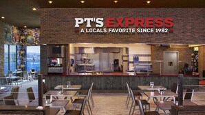 L’intérieur d’un restaurant, avec un comptoir, un espace pour s’asseoir et une vue sur l’extérieur.