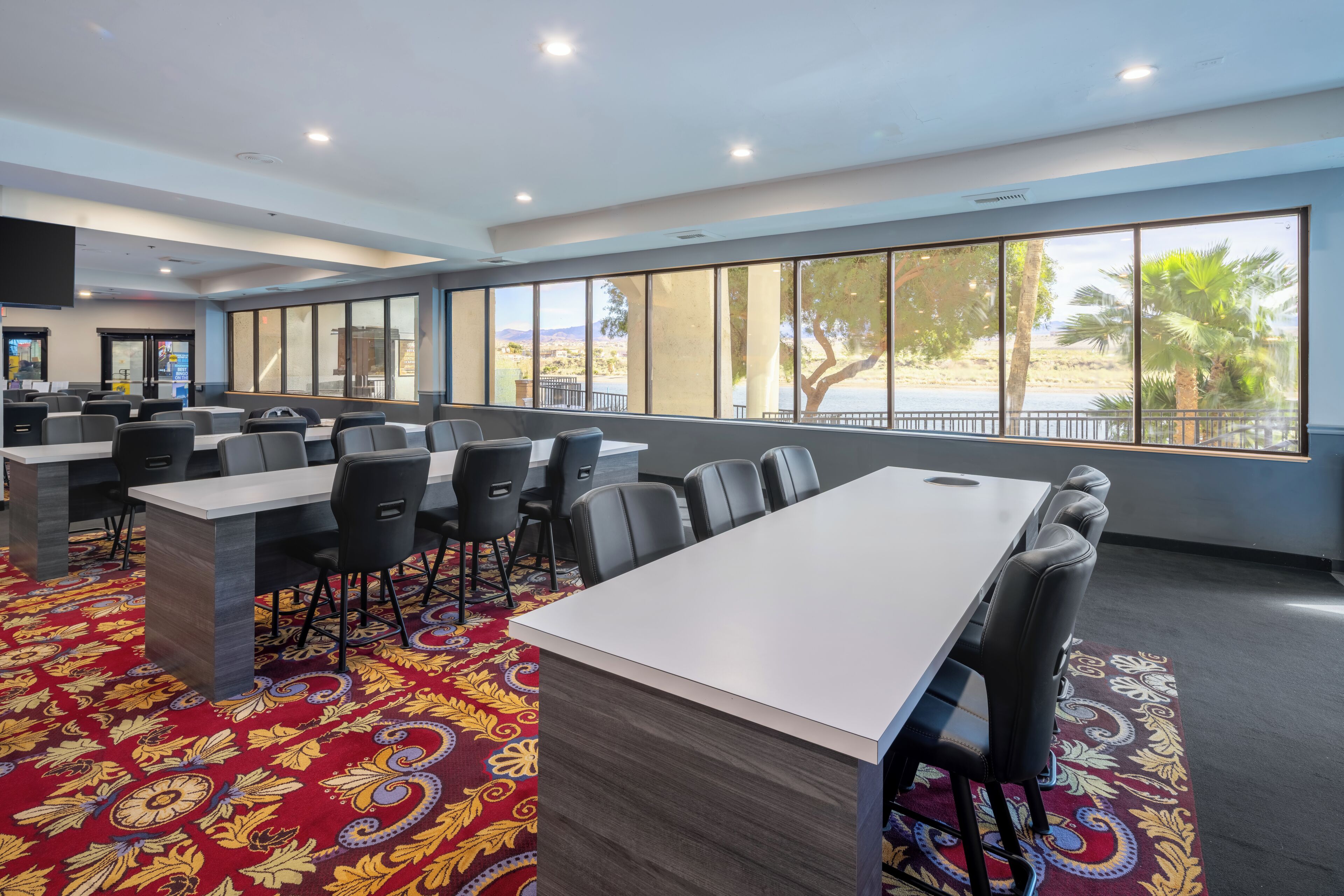 Une salle de conférence avec une longue table, des chaises et de grandes fenêtres donnant sur la plage.