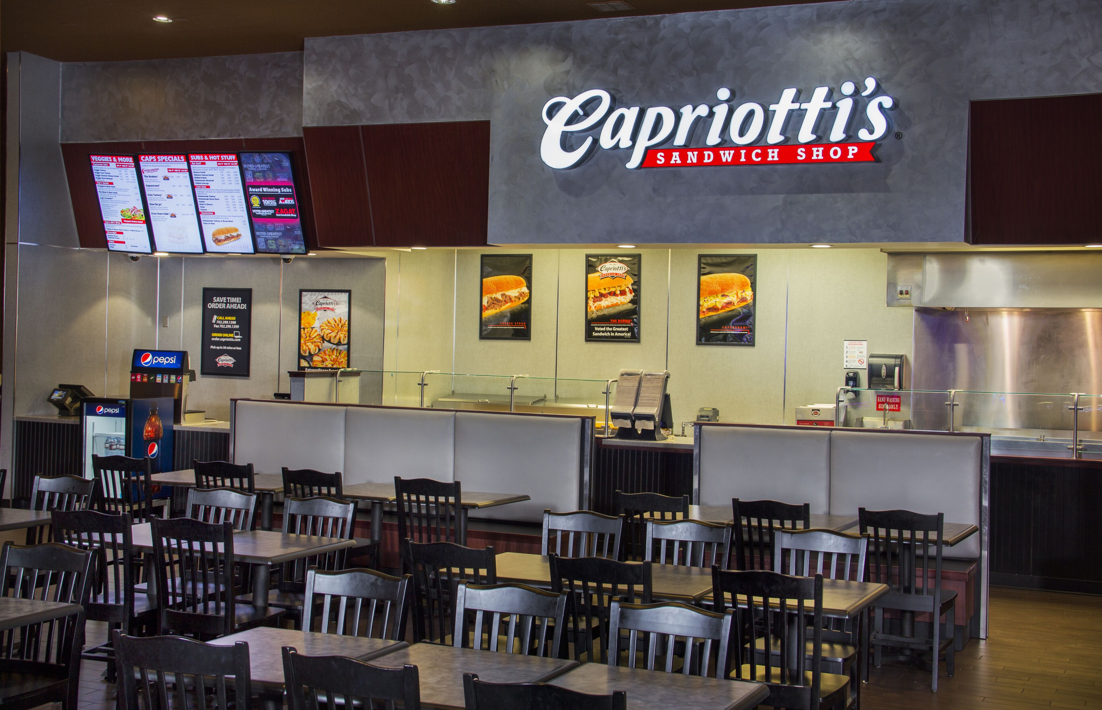 A restaurant with a menu board, seating area, and a counter.