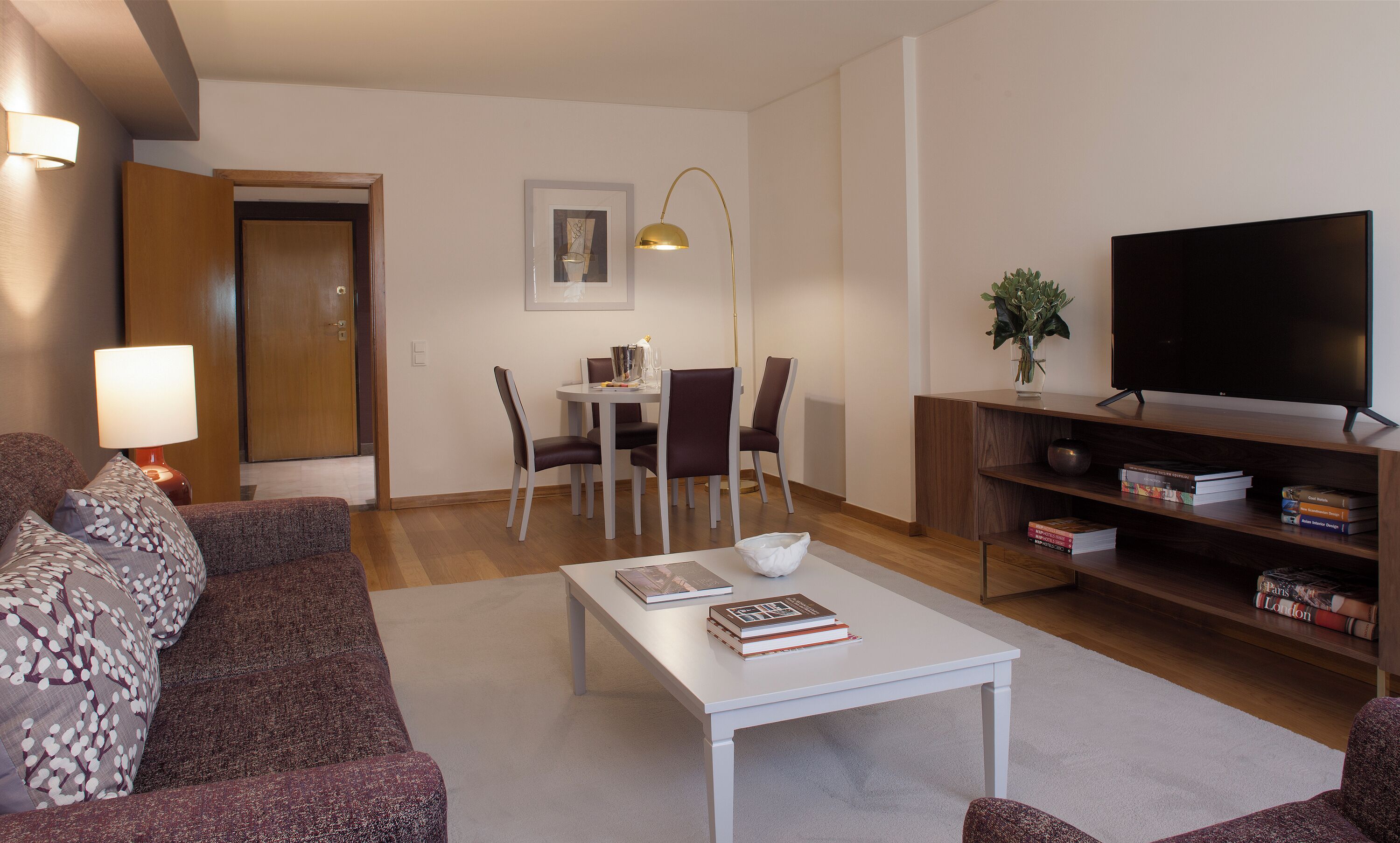 Ein modernes Wohnzimmer mit einer Couch, einem Couchtisch, einem Fernseher und einem Bücherregal.