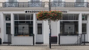 A hotel facade with a balcony, a hanging flower basket, and a sign for 'PADDINGTON PARK HOTEL'. - Paddington Park Hotel (London)