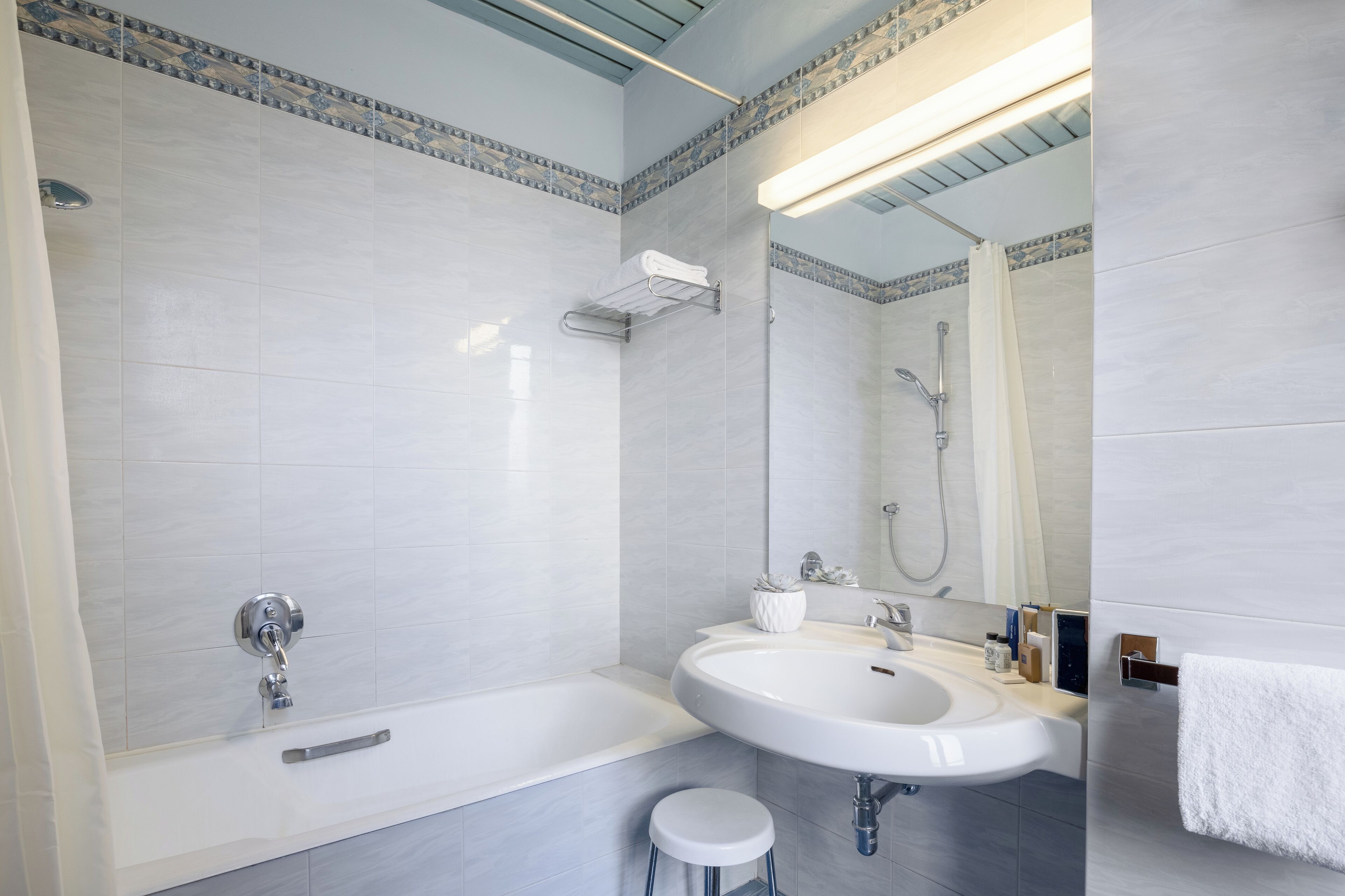 Ein modernes Badezimmer mit einer Badewanne, einem Waschbecken und einer Dusche.
