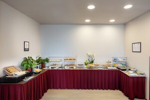 A buffet table with various food items and a potted plant.