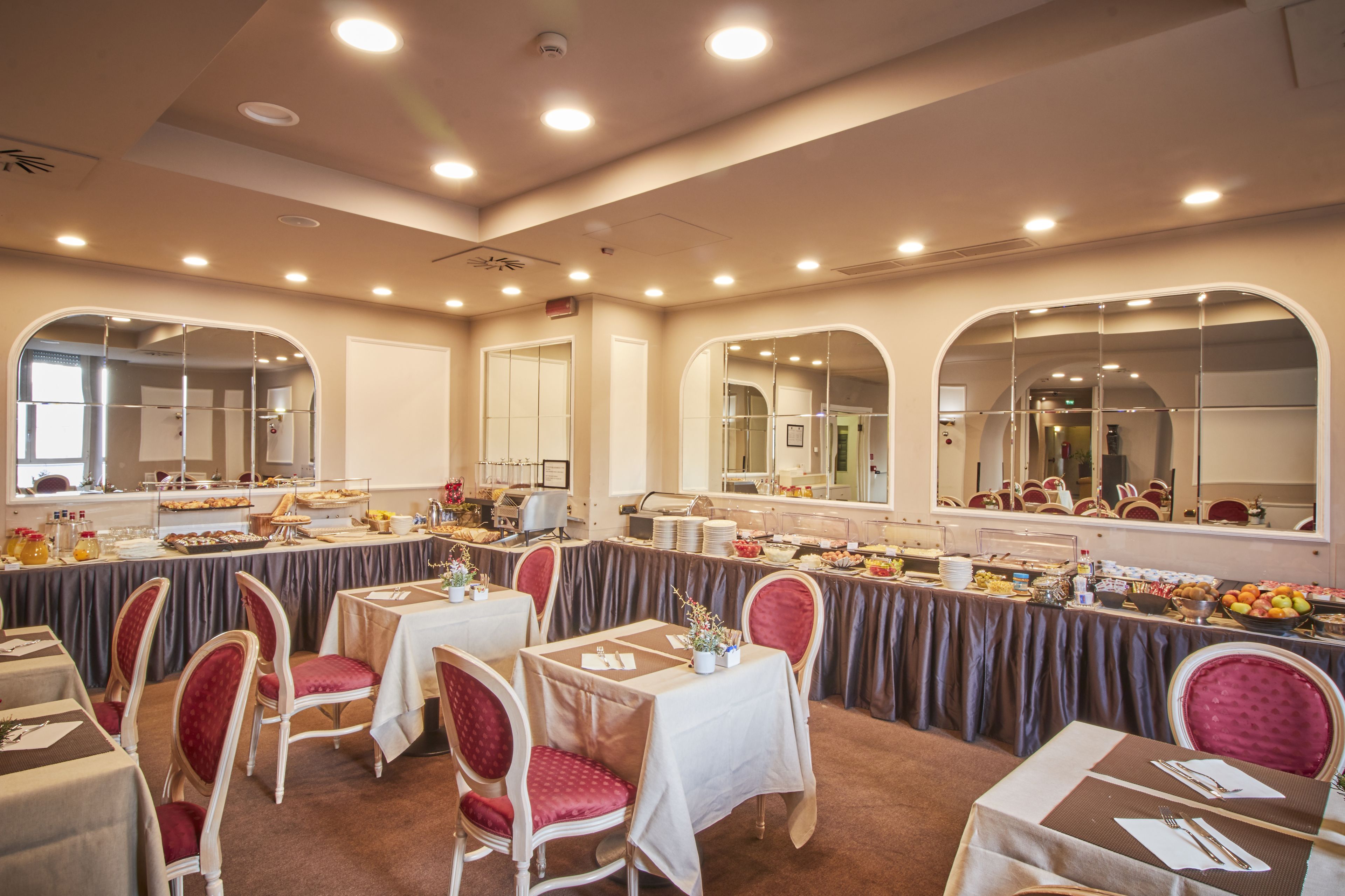 Un salón de banquetes con mesas redondas, sillas y una zona de bufé.