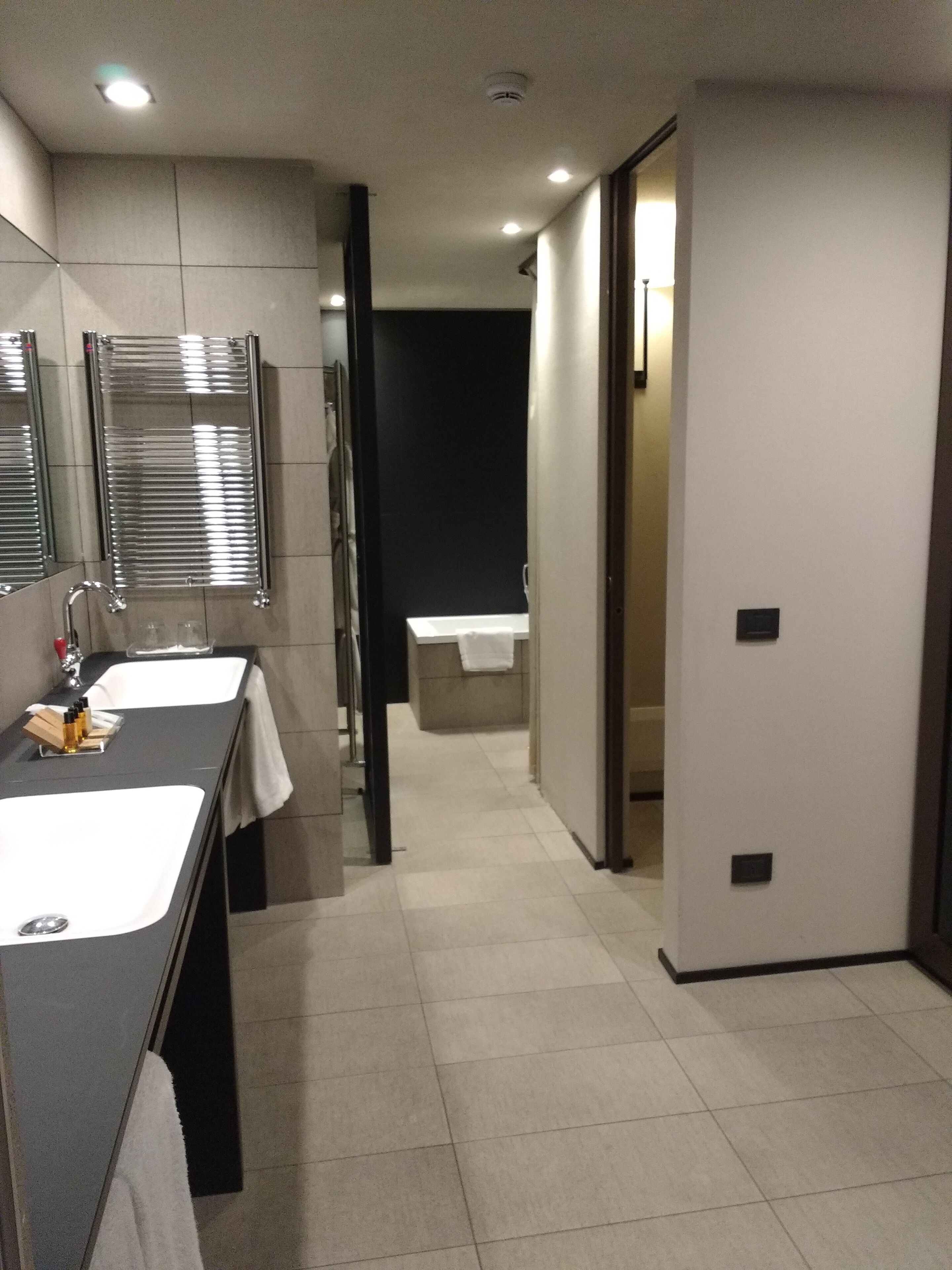Un baño moderno con dos lavamanos, un espejo y un perchero para toallas.