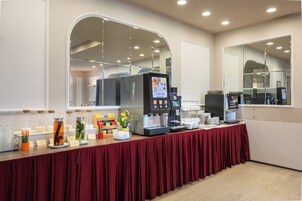 A buffet setup with a coffee station, tea station, and various food items.