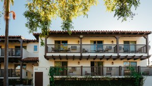 A multi-story building with balconies, a covered patio, and a gate marked with the number 424. - Palmoro House (Santa Barbara)