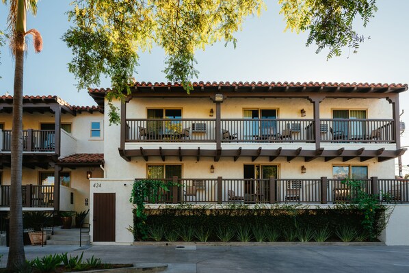 A multi-story building with balconies, a covered patio, and a gate marked with the number 424.