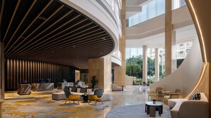A spacious lobby with a curved ceiling, multiple seating areas, and a marble floor. - Sheraton Chengdu Lido Hotel (Chengdu)