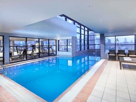 Una piscina techada, sillones reclinables de piscina
