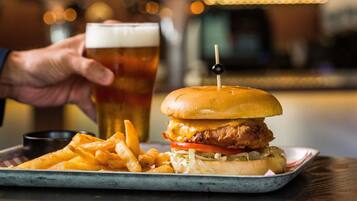 A meal with a burger, fries, and a glass of beer on a tray.