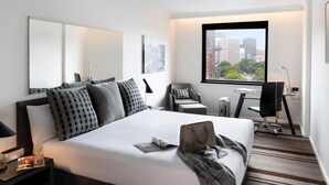 A modern hotel room with a large bed, a desk, and a chair. - Mercure Sydney (Chippendale)