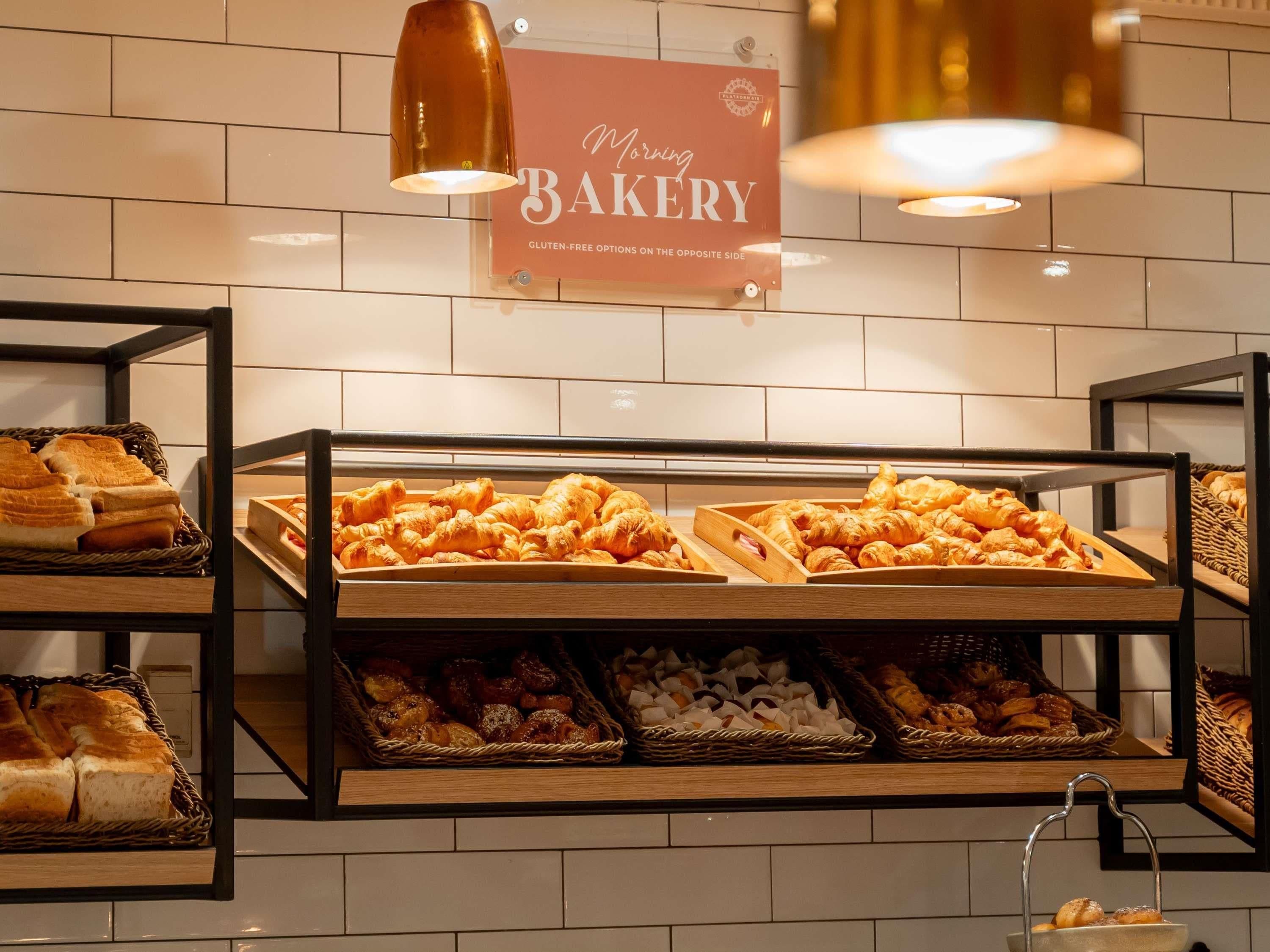 A bakery display with various baked goods and a sign indicating gluten-free options.