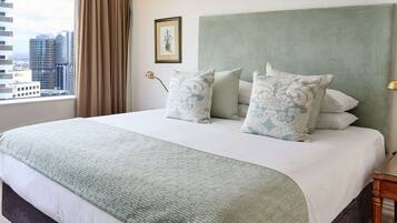Habitación de hotel con una cama grande, vistas de la ciudad y un cuadro en la pared.