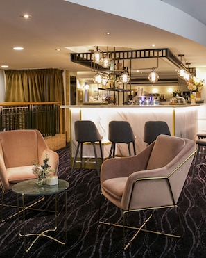 A modern bar area with a marble countertop, bar stools, and a decorative light fixture. - The Sebel Quay West Suites Sydney (The Rocks)