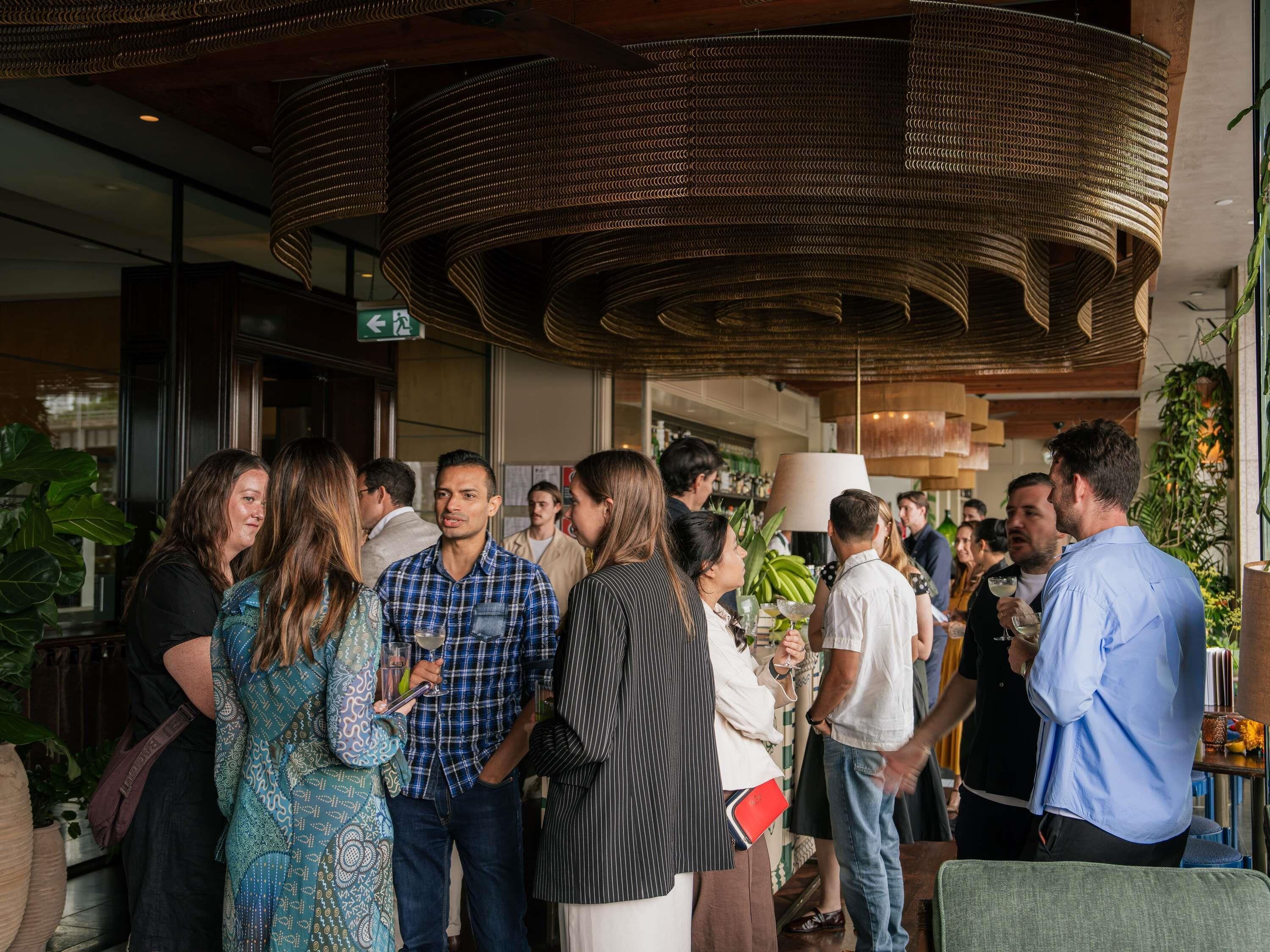 Un grupo de personas en un ambiente interior moderno con techo curvo y luz natural.