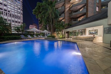 Una piscina al aire libre, sombrillas