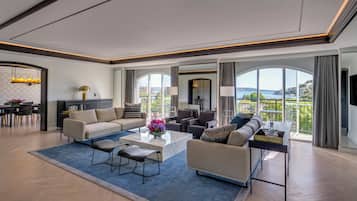 A spacious living room with a large sofa, coffee table, and dining area.