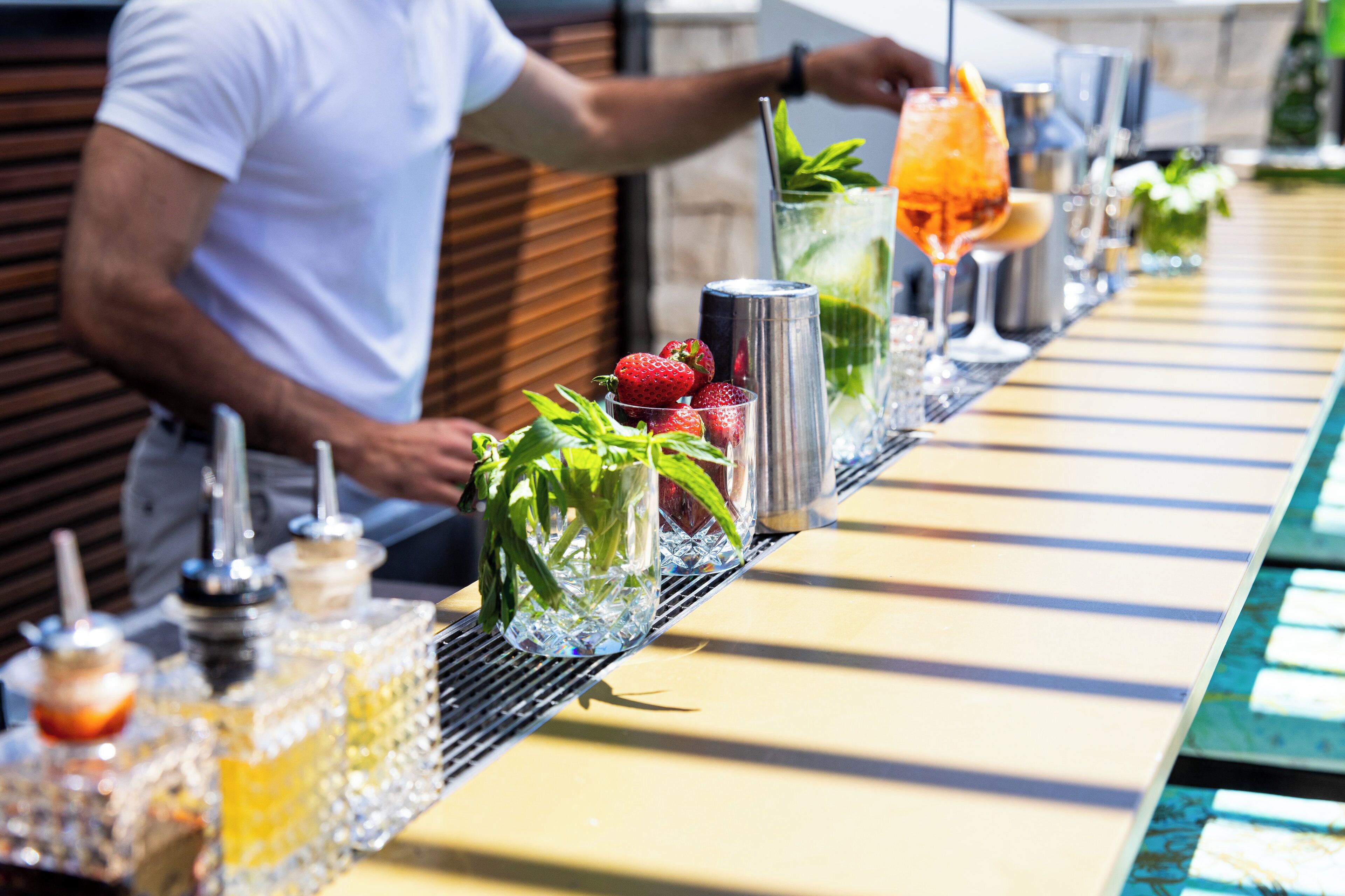 A bar setup with a variety of drinks and garnishes.
