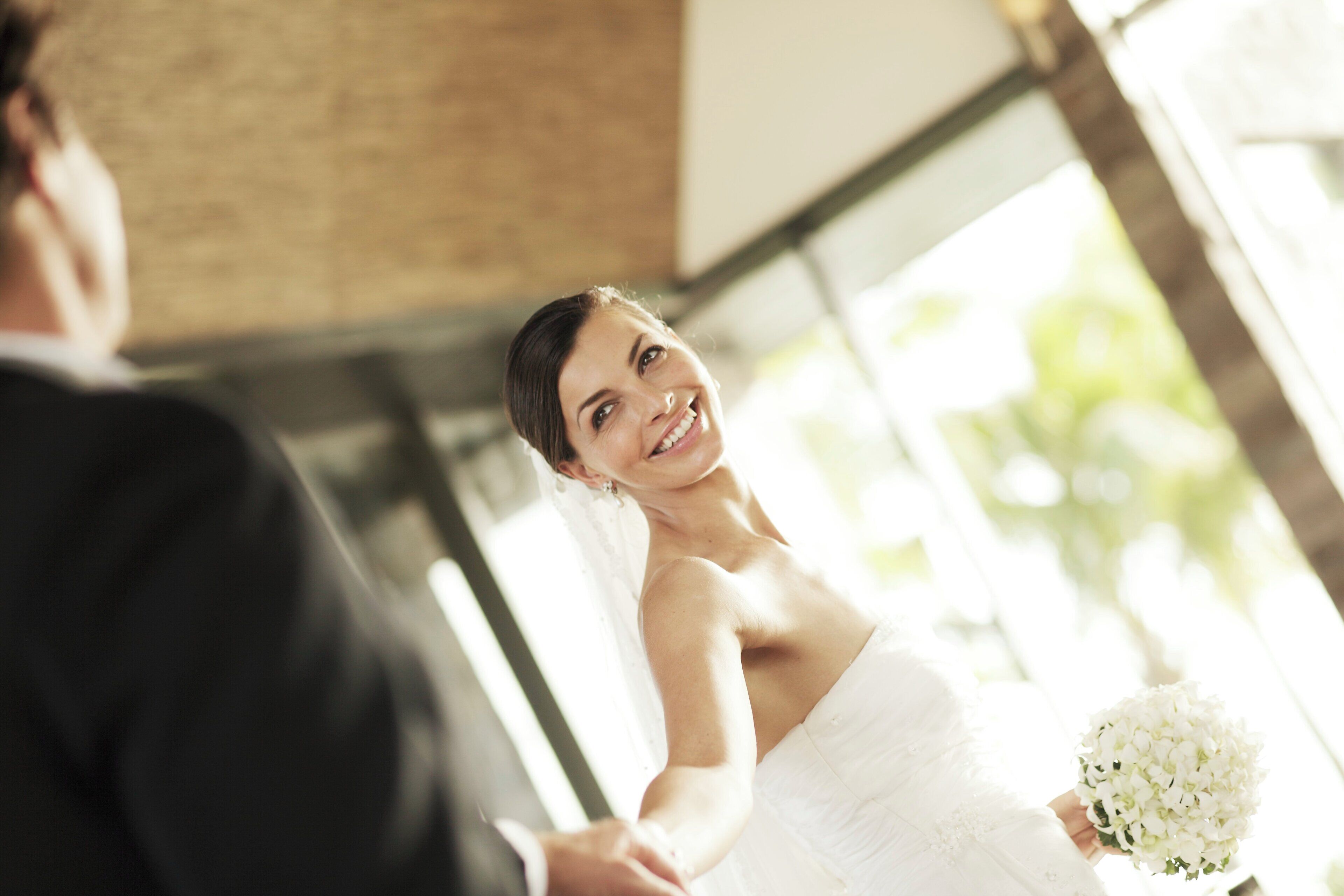 Une cérémonie de mariage où la mariée porte une robe blanche et tient un bouquet, et le marié est en costume.