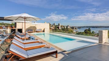 Relax by the rooftop pool overlooking the city and water.
