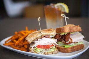 A sandwich with bacon, lettuce, and tomato, and a side of fries.