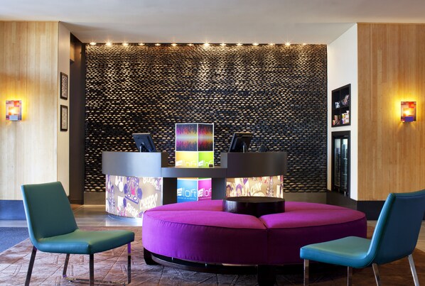 A reception area with a modern design, featuring a reception desk, a colorful wall, and seating arrangements.