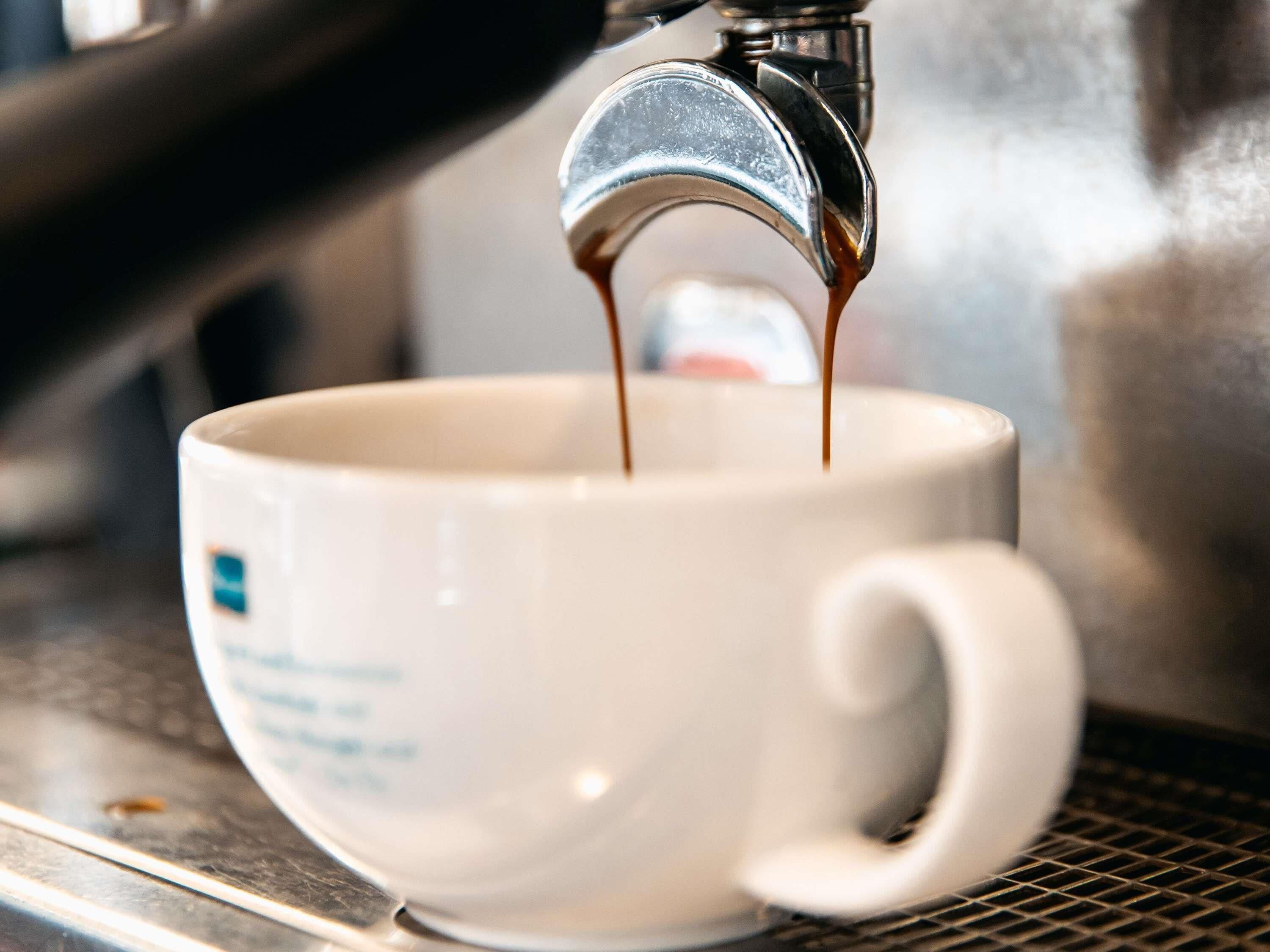 A cup being filled with coffee from a machine.