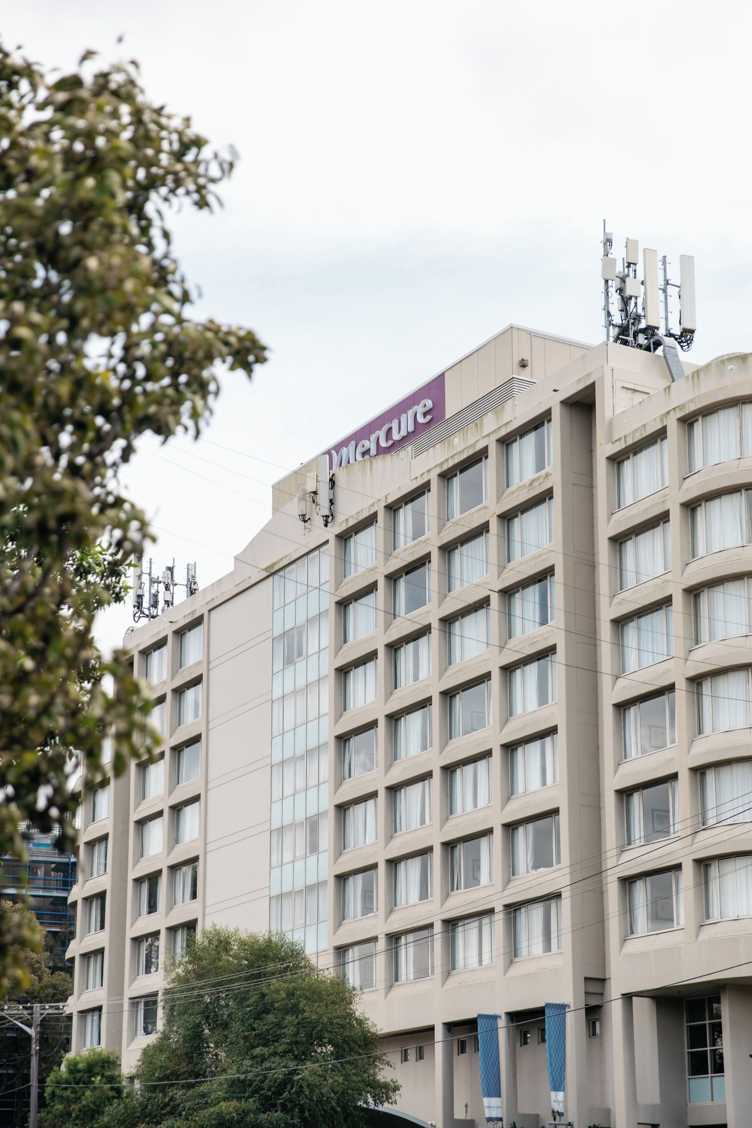 A hotel with a modern facade, multiple floors, and a prominent sign.